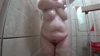 Peeping after the milf who washes in the shower. Mature plump figure with large tits and a juicy butt.